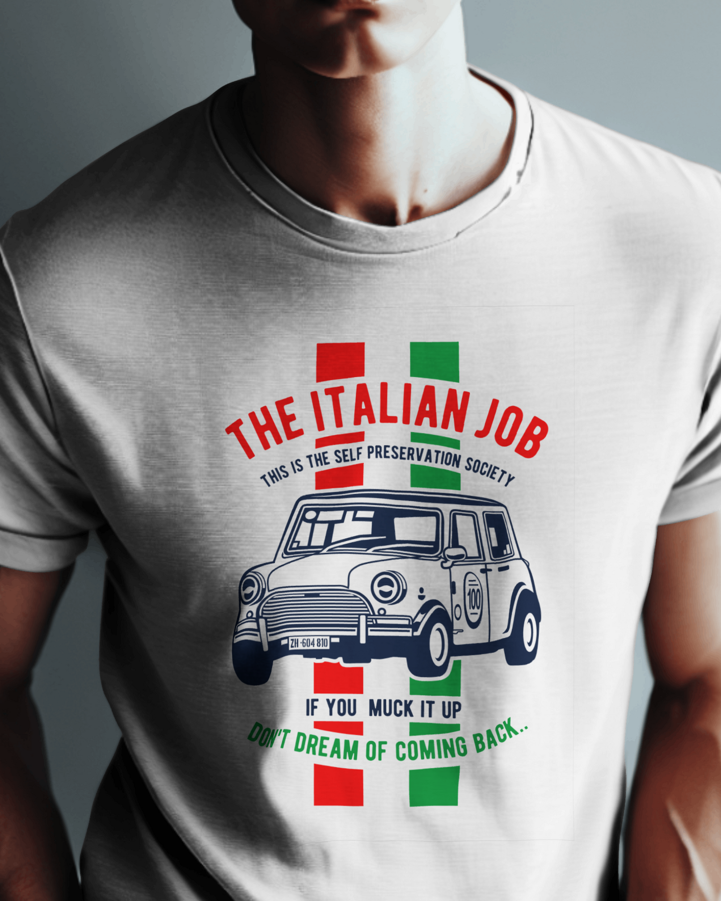 the t-shirt image shows a white shirt with a blue mini cooper illustration. above the car, in red text, is "the italian job", while below it, green text says "if you muck it up, don't dream of coming back". the slogan "this is the self preservation society" is included in the design, with red and green accents representing the italian flag.