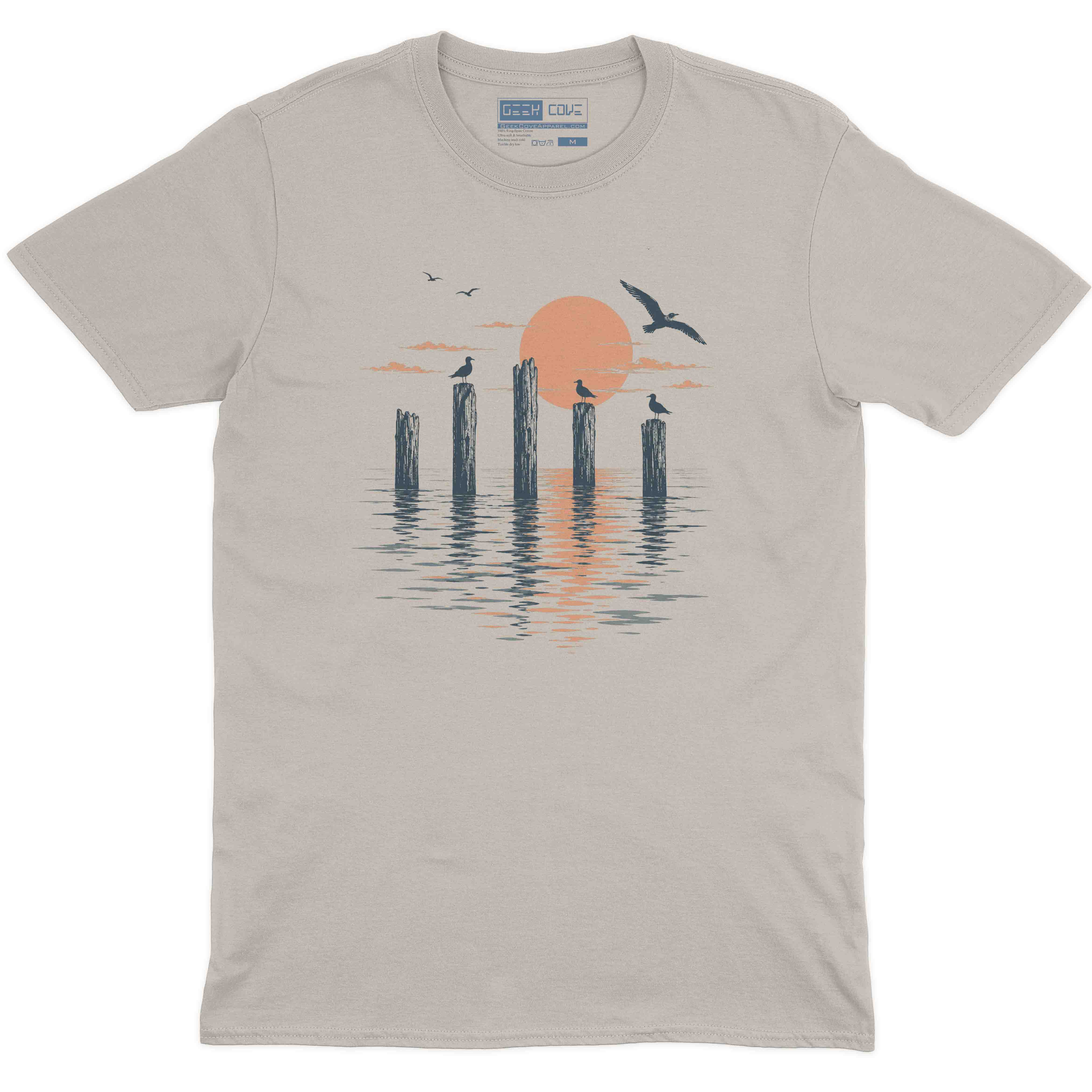 Coastal men graphic tee featuring wooden pilings, flying birds, and a peach sunset