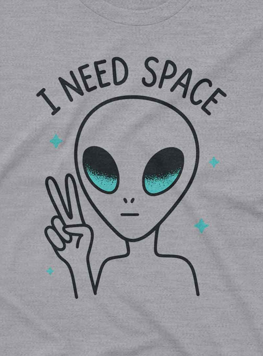 A simple gray t-shirt featuring a cartoon alien making a peace sign with the text “I Need Space.”