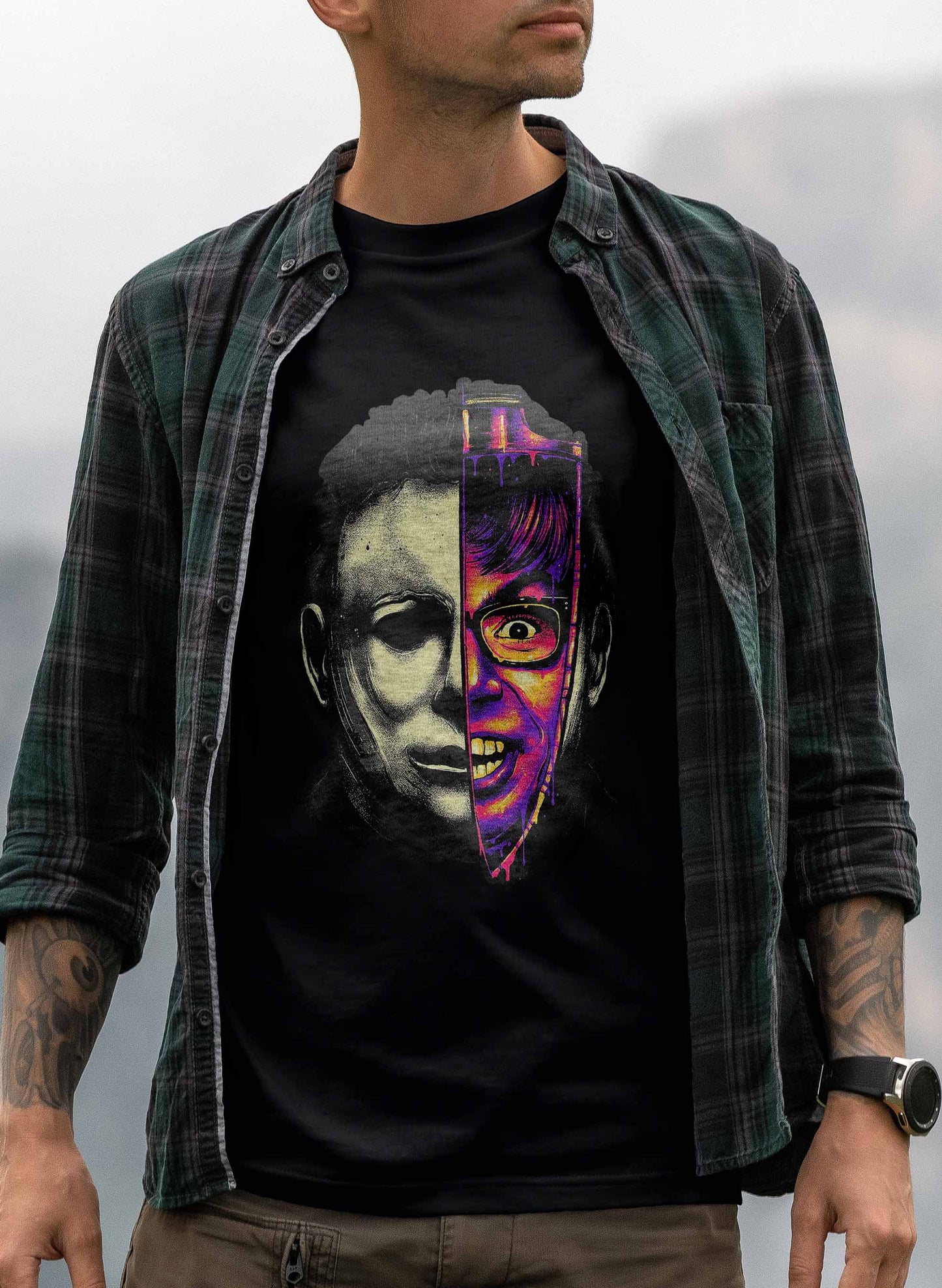 graphic tee with half-face of michael myers in monochrome and norman bates in vibrant neon colors.