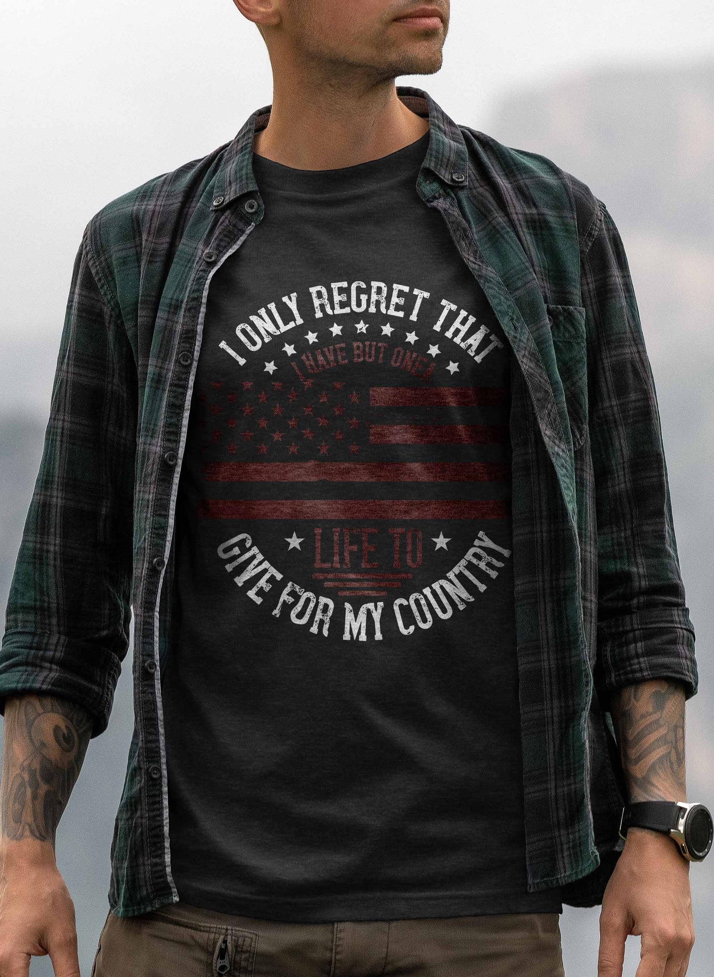 a t-shirt design showcasing a distressed american flag, with stars on the upper half and stripes on the lower half, all in muted tones. the phrase "i only regret that i have but one life to give for my country" curves around the top and bottom of the flag, symbolizing deep national pride and sacrifice.