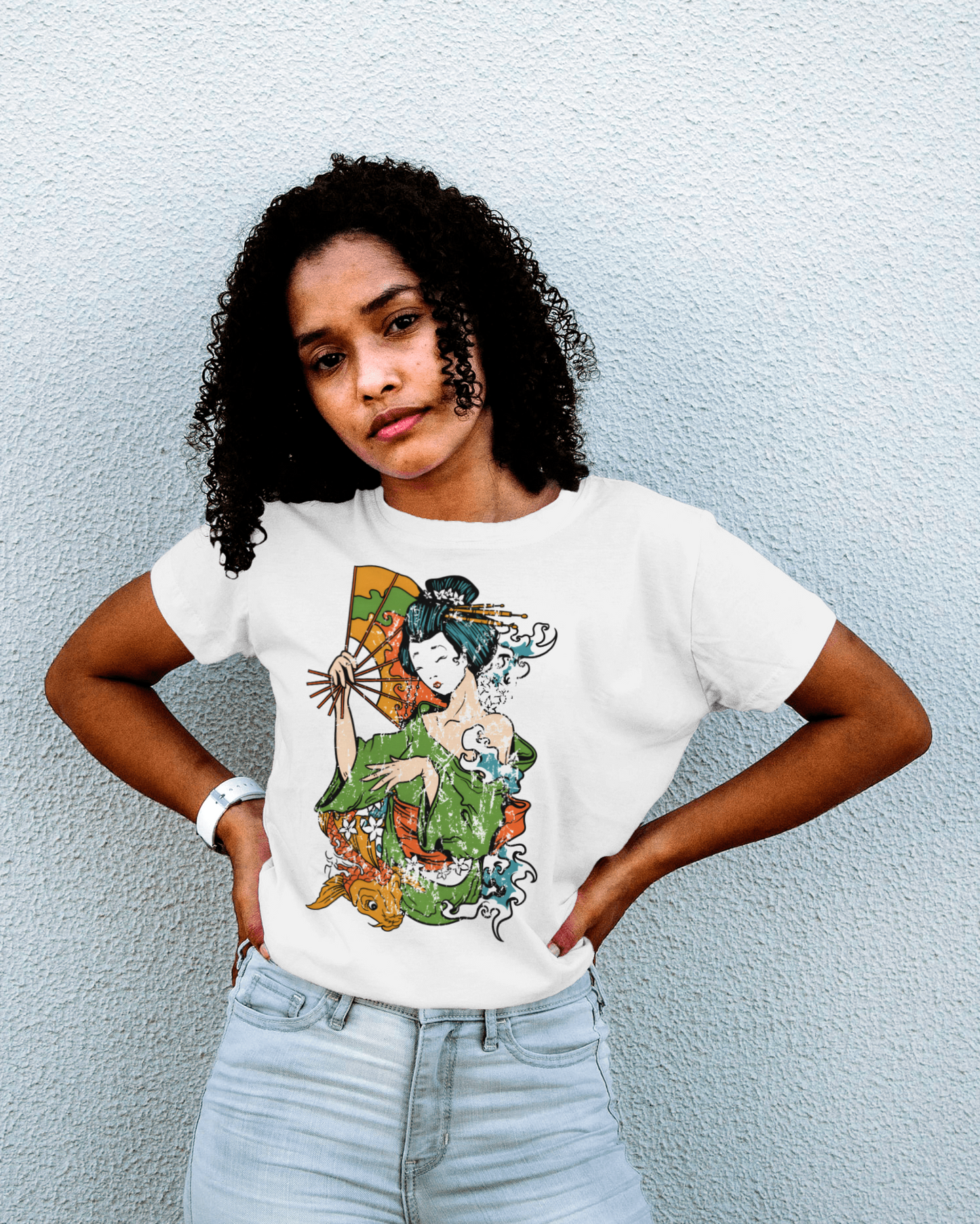 a detailed graphic on a t-shirt shows a traditional japanese geisha in a striking pose with a fan in her hand. the geisha is wearing a green kimono, and the design includes artistic representations of water waves and orange koi fish, giving it a dynamic and traditional aesthetic.